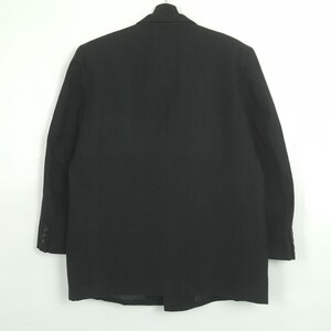 May include: A white ceramic mug with a black handle and the text "But First, Coffee" in a black, bold font. The mug is on a white surface. The mug is likely for hot beverages.