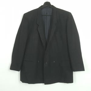 May include: A black double-breasted blazer with a notched lapel, two rows of buttons, and two front pockets. The blazer is hanging on a black hanger against a white background. The jacket has a classic, tailored design.