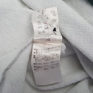 May include: Close-up of a white fabric with a tag attached. The tag has Japanese text and details about the fabric composition: 95% cotton, 5% polyurethane, and 100% acrylic. The tag also includes washing instructions.