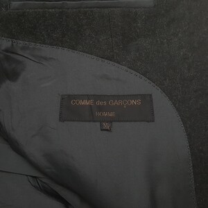 May include: A set of three ceramic mugs with a speckled, matte finish. The mugs are in shades of cream, light gray, and dark gray. Each mug has a simple, modern design and a rounded handle.