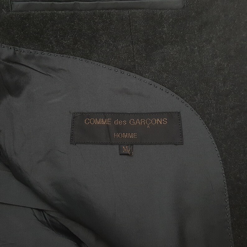 May include: A set of three ceramic mugs with a speckled, matte finish. The mugs are in shades of cream, light gray, and dark gray. Each mug has a simple, modern design and a rounded handle.