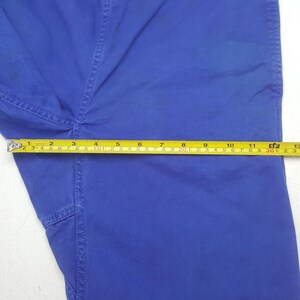 Puede incluir: Primer plano de pantalones azules con una cinta m&eacute;trica amarilla. La cinta muestra una medida de aproximadamente 30 cm. Los pantalones tienen costuras visibles y un detalle de bolsillo.
