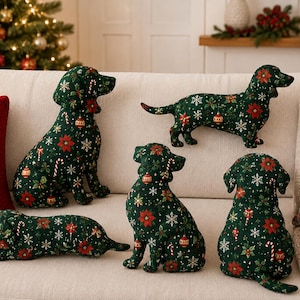 Puede incluir: Cinco cojines de peluche con forma de perro en tela verde oscuro con un patrón festivo de flores de pascua rojas, copos de nieve blancos, bastones de caramelo y adornos dorados. El conjunto incluye varias posturas de perros, sentados, de pie y tumbados.