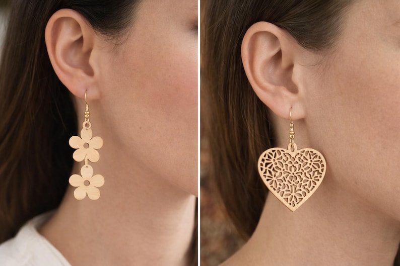May include: Gold-colored earrings in two styles: one with two flower shapes, the other with a heart-shaped filigree design. The earrings are hanging from the ear of a person.
