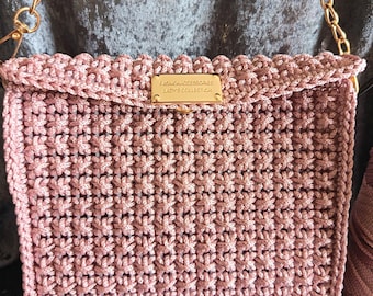 pink handbag with gold chain shoulder strap
