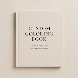 以下が含まれることがあります： クリーム色のカスタム塗り絵本。太字の黒いフォントで「CUSTOM COLORING BOOK」と書かれています。下には「YOUR PHOTOS TO COLORING PAGES」と書かれています。本は閉じられており、中央に配置されています。