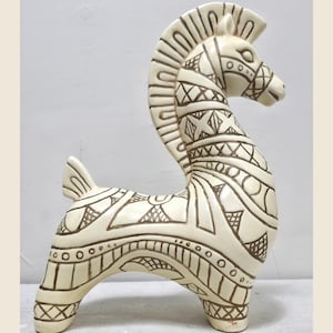 May include: Cream-colored ceramic horse figurine with intricate dark brown geometric patterns. The horse has a stylized mane and tail, and the design covers the entire body. A decorative piece for home decor.