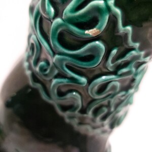 Puede incluir: Un jarr&oacute;n de cer&aacute;mica verde oscuro con un dise&ntilde;o verde en espiral en relieve.