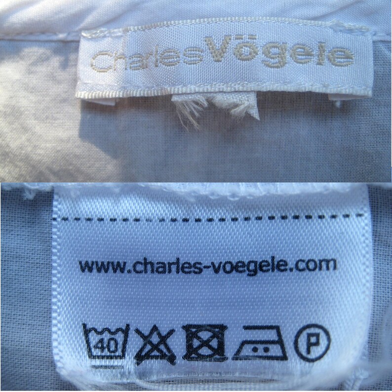 May include: Close-up of two white fabric labels. The top label reads "Charles V&ouml;gele" in a light gray font. The bottom label displays "www.charles-voegele.com" and laundry symbols, including a 40-degree wash symbol.