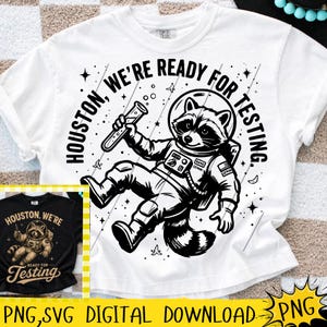 Puede incluir: Camiseta blanca con un gráfico en blanco y negro de un mapache astronauta sosteniendo un tubo de ensayo. El texto "HOUSTON, WE'RE READY FOR TESTING" está impreso alrededor del mapache. Una imagen más pequeña del diseño en una camiseta negra es visible.