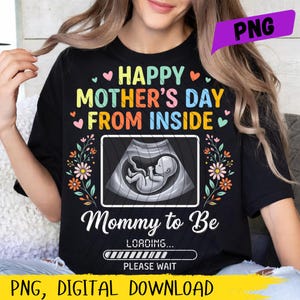 May include: Black t-shirt with the text "HAPPY MOTHER'S DAY FROM INSIDE" in colorful letters. The shirt features an ultrasound image of a fetus and the words "Mommy to Be" with a loading bar. Floral accents and hearts decorate the design.