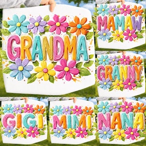 May include: White sign with the word "GRANDMA" in colorful 3D letters, surrounded by a floral border of blue, purple, pink, yellow, and orange flowers with green leaves. Other signs say "MAMAW", "GRANNY", "GIGI", "MIMI", and "NANA".