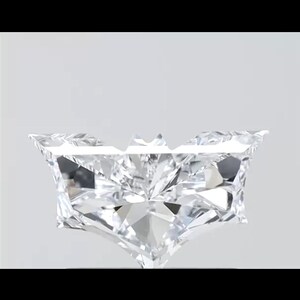 May include: A clear, princess-cut diamond with multiple facets, reflecting light. The diamond is set against a white background, showcasing its brilliance and clarity. The shape is a modified square with a pointed bottom.