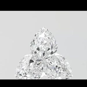 May include: A close-up of three clear, faceted diamonds. The diamonds are pear-shaped and arranged in a cluster, with the largest diamond at the top. The facets reflect light, creating a sparkling effect against a white background.