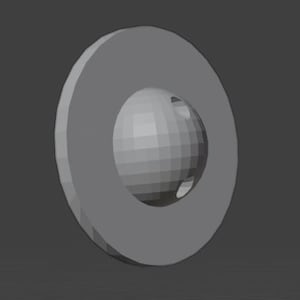 May include: A gray, geometric 3D rendering of a ring shape with a sphere inside. The ring and sphere are both gray and have a faceted, polygonal appearance, suggesting a digital model.