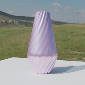 May include: A lavender vase with a swirling pattern. The vase has a broad base that narrows towards the top. It is placed on a white surface, with a natural landscape visible in the background.