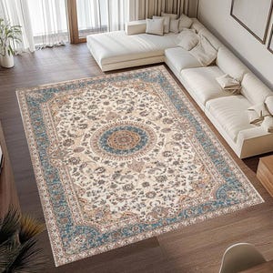 May include: An ornate area rug with a cream-colored background and a detailed floral pattern. The rug features a central medallion design in shades of blue, brown, and gold, with a border in a similar color palette. The rug is rectangular.