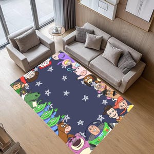 Op de afbeelding: Een rechthoekig vloerkleed met een marineblauwe achtergrond en witte sterpatronen. Het vloerkleed heeft illustraties van stripfiguren langs de rand. Het vloerkleed ligt in een woonkamer met meubels.