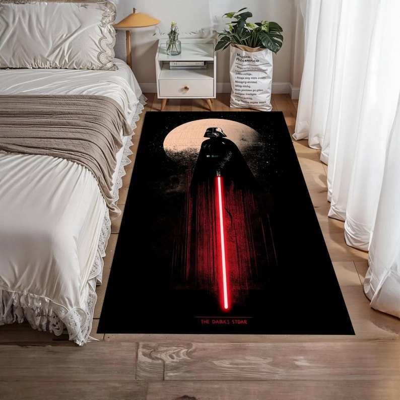 Puede incluir: Alfombra rectangular negra con Darth Vader con un sable de luz rojo sobre un fondo de luna. La alfombra tiene el texto "THE DARK SIDE" en la parte inferior. La alfombra est&aacute; sobre un suelo de madera.