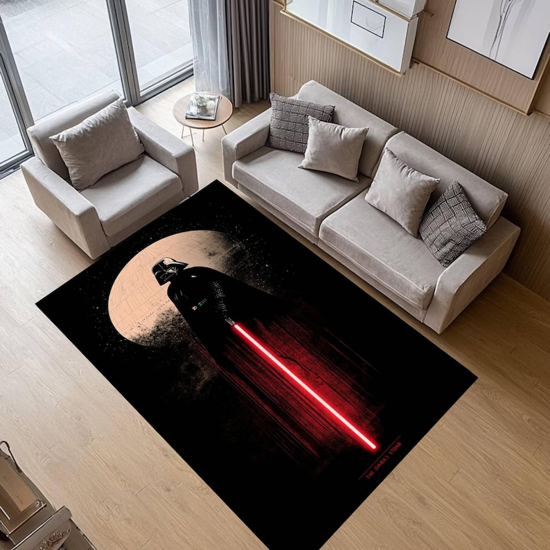 Puede incluir: Alfombra rectangular negra con Darth Vader con un sable de luz rojo sobre un fondo de luna y estrellas. La alfombra tiene un tema de Star Wars y est&aacute; colocada en un sal&oacute;n.