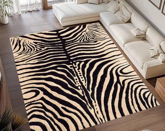 May include: A rectangular area rug with a zebra stripe pattern in black and beige. The rug is placed on a hardwood floor, and a white sectional sofa is visible in the background.