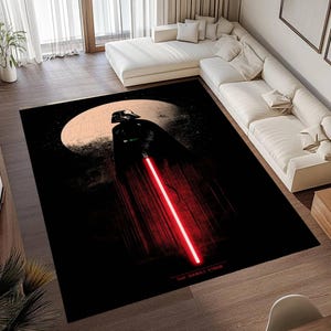 Puede incluir: Una alfombra rectangular negra con Darth Vader de Star Wars. La imagen muestra a Darth Vader con un sable de luz rojo sobre un fondo de luna y cielo oscuro. Las palabras "THE DARK SIDE" est&aacute;n en la parte inferior.