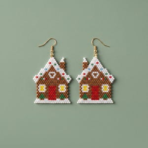 May include: A pair of dangle earrings crafted from small beads in the shape of gingerbread houses. The houses feature brown walls, a red door, yellow windows, and a white roof with colorful accents, all suspended from gold-toned metal hooks.