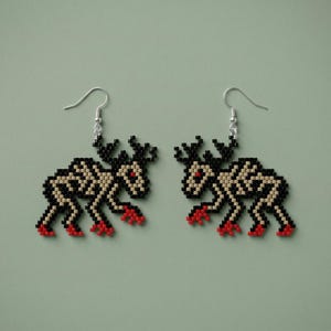 May include: A pair of beaded earrings featuring a skeletal deer design. The earrings are primarily black and beige, with red accents on the hooves and eyes. The earrings have silver-colored ear wires and are set against a muted green background.