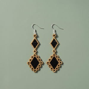 May include: A pair of drop earrings featuring a geometric diamond pattern crafted from small black and metallic gold beads. Each earring consists of a smaller diamond shape suspended above a larger diamond shape, attached to silver-toned metal hooks.