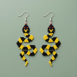 May include: A pair of beaded snake earrings. Each earring features a black and yellow snake design with red accents. The snakes have black and yellow segmented bodies and red eyes. The earrings hang from silver-colored hooks.