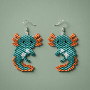 May include: A pair of beaded axolotl earrings. The earrings feature a teal body with orange gills and tail, and white accents. The axolotls have small black eyes and are suspended from silver-colored fish hook ear wires.