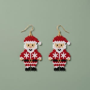 May include: A pair of dangle earrings featuring a Santa Claus figure crafted from small red, white, black, and beige beads. Each earring has a gold-toned metal hook and depicts a Santa with a red hat, white beard, and black belt.