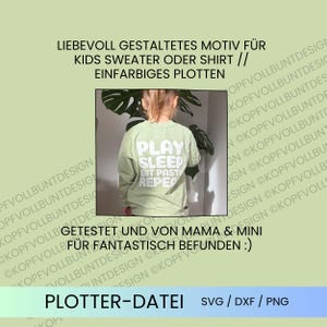 May include: A light green long-sleeve sweatshirt featuring white text on the back that reads PLAY SLEEP EAT PASTA REPEAT. The garment is displayed in a central rectangular frame against a light green background with repeating text.