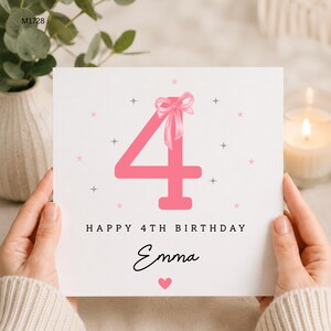 Könnte beinhalten: Eine quadratische weiße Geburtstagskarte mit einer großen rosa Zahl 4, die oben mit einer rosa Schleife verziert ist. Die Karte enthält den Text HAPPY 4TH BIRTHDAY und den Namen Emma in schwarzer Schreibschrift, umgeben von rosa Sternen und grauen Funken.