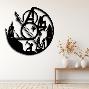 Op de afbeelding: Zwarte metalen wandklok met een cirkelvormig ontwerp, met het Avengers-logo en silhouetten van personages. De klok heeft een moderne, minimalistische stijl, geschikt voor een woonkamer of slaapkamer. De klok is aan een witte muur bevestigd.