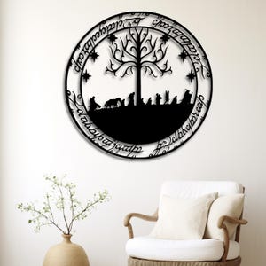 Könnte beinhalten: Schwarze Metall-Wandkunst mit einem Baum, Sternen und Figuren in einem kreisförmigen Design. Das Kunstwerk enthält Schrift am Rand und ist an einer weißen Wand befestigt. Ein dekorativer Artikel.