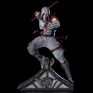 May include: A detailed statue of a ninja in a dynamic pose, clad in a gray and white outfit with red accents. The figure is holding two red katanas, with a cobra emblem on the chest. The statue is mounted on a detailed rooftop base.
