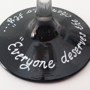 May include: Black wine glass with white lettering that reads "Everyone deserves the chance to..."