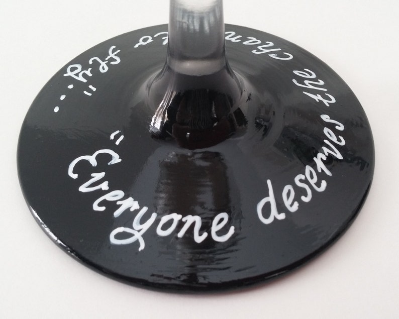 May include: Black wine glass with white lettering that reads "Everyone deserves the chance to..."
