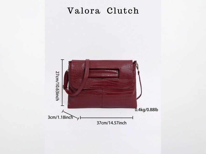 Peut inclure: Un sac Valora Clutch bordeaux avec une finition textur&eacute;e. Le sac mesure 37 cm de large, 27 cm de haut et 3 cm de profondeur. Il p&egrave;se 0,4 kg. Le sac a une bandouli&egrave;re et une forme rectangulaire.