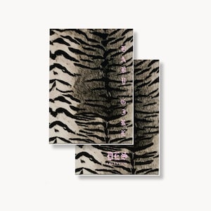 May include: Two rectangular cards featuring a black and beige tiger stripe pattern. The top card displays the vertical text BABY GIRL in a light pink gothic font. The bottom card shows the text DES in a matching light pink gothic font.