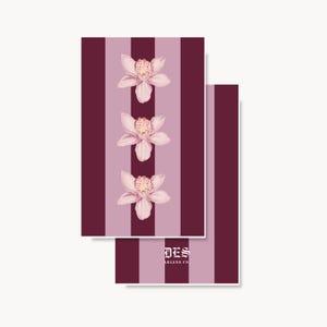 May include: Two rectangular cards featuring a vertical striped pattern in alternating shades of dark maroon and light mauve. The front card displays three light pink orchid illustrations arranged vertically. The back card shows the text DES ARLENE CO.