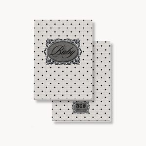 May include: Two rectangular cards with a white background and a black polka dot pattern. The top card features an oval frame with the word Baby in script. The bottom card displays a smaller rectangular frame with the text DES ARLENE CO.