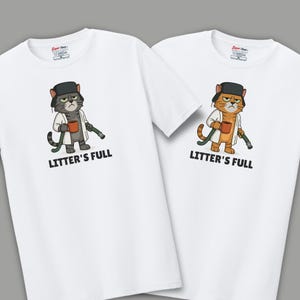 May include: Two white t-shirts with a cartoon cat design. The cat wears a hat, lab coat, and holds a mug and a hose. The text "LITTER'S FULL" is printed below the cat. One cat is gray, the other is orange.