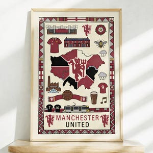 Puede incluir: Impresión enmarcada con un mapa de Manchester, Inglaterra, e imágenes del Manchester United. Incluye un estadio, una camiseta, una abeja y las palabras "Manchester United". La impresión está en un marco de madera.
