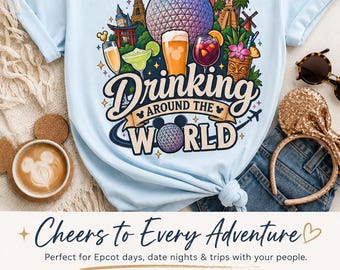 May include: A light blue t-shirt featuring a colorful graphic of global landmarks and various cocktails. The text reads Drinking Around The World, with a stylized globe icon. The design includes illustrations of a beer, margarita, and tropical drinks.