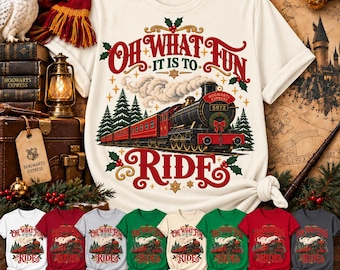 Op de afbeelding: Een t-shirt met korte mouwen met een afbeelding van een rode stoomtrein en de tekst Oh What Fun It Is To Ride. Het ontwerp bevat dennenbomen, hulst en rook. Het shirt is verkrijgbaar in wit, kardinaalrood, ijsgrijs, iers groen, naturel, kellygroen, kersenrood en antraciet.