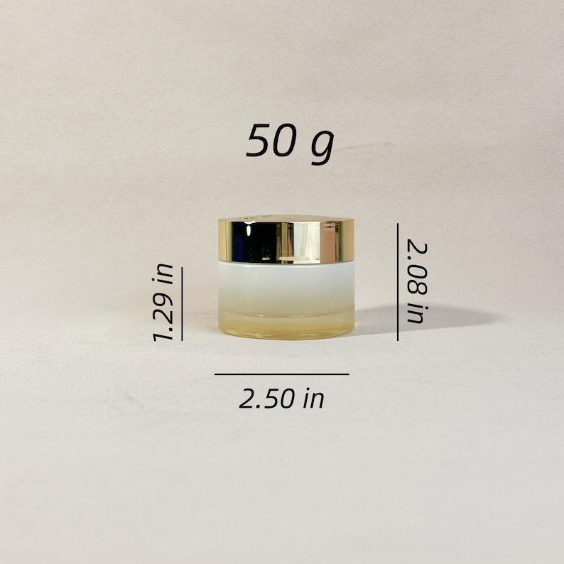May include: A small, frosted glass jar with a gold-colored lid. The jar is 2.50 inches wide, 2.08 inches tall, and 1.29 inches deep. The text "50 g" is printed above the jar.