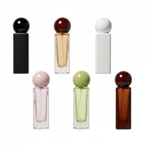 May include: Six perfume bottles are displayed, each with a rectangular base and a spherical cap. The bottles come in various colours: black, brown, white, pink, green, and amber. The clear glass bottles reveal the different coloured perfumes within.