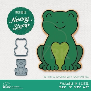 May include: A green frog cookie cutter with a heart-shaped belly, a nesting stamp, and a 3D-printed frog. The image includes the text "INCLUDES Nesting Stamp" and "AVAILABLE IN 4 SIZES 2.25" - 4.5"".